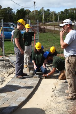 In another hands-on demonstration, students help to install pavers for a curved walkway at the venue where the Career Day took place.