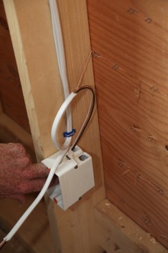 After both cables have been stripped, the author feeds the first cable into the box in a loop. The loop gives the crew extra length in case one of the connectors gets damaged during drywalling.