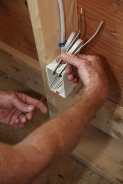 After both cables have been fed into the box, the ground conductors are separated fron the other conductors.