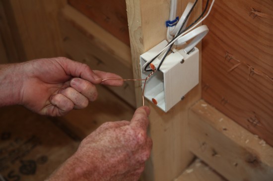 The author starts by twisting the two ground conductors together by hand.