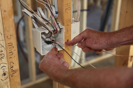 With two ground conductors in one hand and three in the other, the author begins to twist them together.
