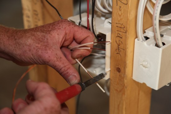 After cutting the neutrals in each bundle to a length of 6 to 8 inches, about an inch of insulation is stripped from the ends of the conductors. 