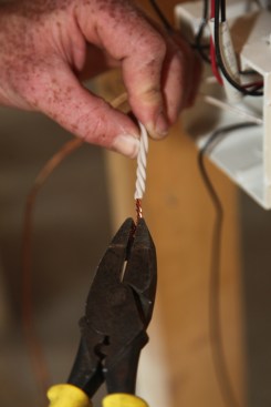 Pliers twist the bundle of neutrals, joining the bare ends as well as twisting a short length of the insulated sections together.