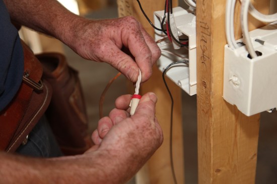 Twist the appropriate size wire nut onto the bundle tightening it by hand as much as possible.