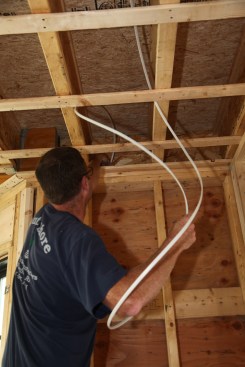 To keep the cable flat and without a twist, the author makes a large gentle loop in the cable as he feeds it through the hole drilled in the plates.  