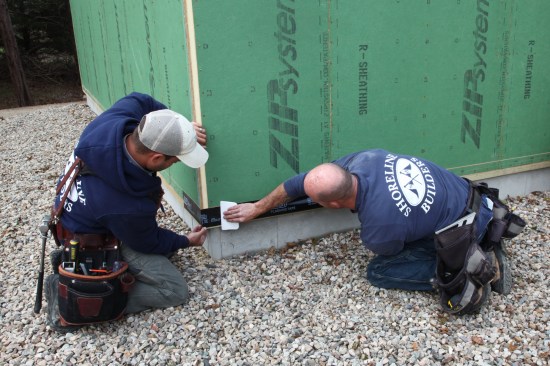 A crew of two always makes for a more precise installation of the flashing tape. One of the crew unrolls the tape pulling it out straight while the other does the initial adhesion by hand. 