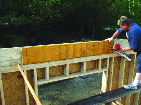 An LVL installed inside the regular rim joist acts as a header for the window opening below.