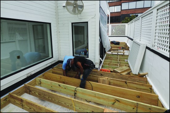 Where the roof deck is enclosed by a masonry parapet, ledgers can simply be bolted to the house framing and parapet to support standard deck joists.