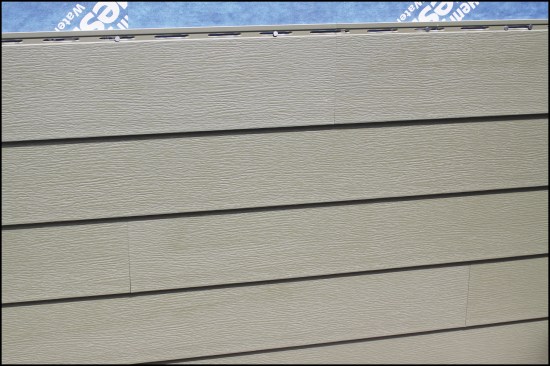With Royal Building Products Celect siding, seams (butt joints) are shiplapped so each course moves in unison across the length of the wall. Note the double nails in the upper right corner. This is the center of the wall; the double nails “pin” the siding in the middle, so thermal movement happens evenly from the middle out in both directions.