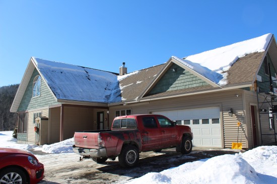 The main house of the L-shaped Cape is in the background, and the garage with the bonus room is on the right.