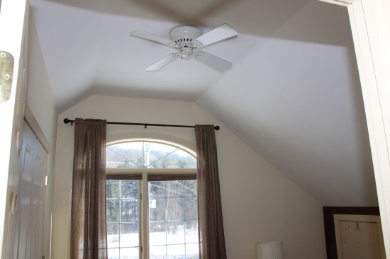 Typical of a Cape, the second-floor interiors have knee walls on either side; the walls sloped inward from the top of the knee walls following the 9:12-pitch roof lines to a narrow, flat ceiling. The homeowners use the space behind the knee walls for storage, which they access via well-sealed but uninsulated hatches from the second-floor rooms or on the back wall of the closets (on the left, a closet was built in front of the knee wall).