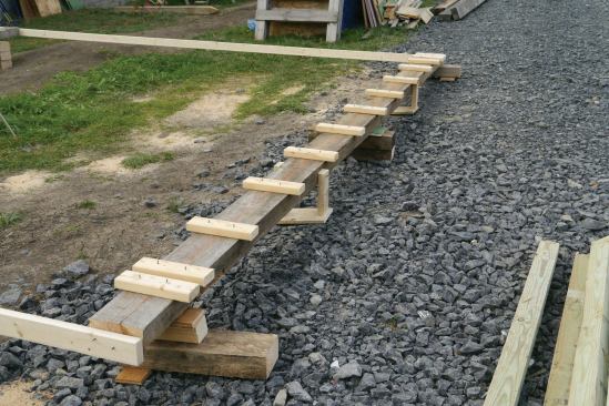 We laid out the trusses along the snapped lines and nailed 2x4 blocks perpendicular to the lines to serve as stops for the trusses to bump against as we set them.