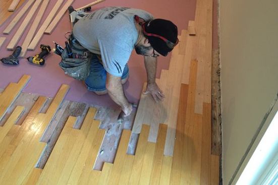 With the board started in the existing space, Manny lightly taps it over against the neighboring board. He is careful not to tap too hard, otherwise he woul damage the tongue and make it hard to get a tight fit with subsequent boards.