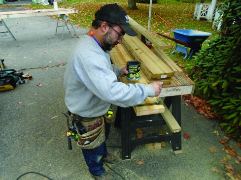After cutting the grooves in the face of the ledger, the cuts are treated with preservative.