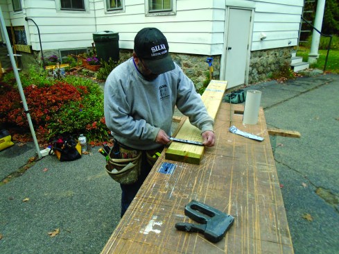 Adhesive-backed membrane attaches to the ledgers to protect the metal straps from the treated wood.