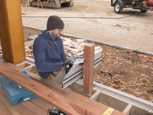 The railing’s finish height was 18 inches, or bench height, above the veranda’s decking, while the deck’s surface itself was 2 feet above the planned final grade—close enough to grade that a guardrail wasn’t required. Here, Keith Jalbert cuts a 4x4 mahogany support post to height with a Festool saw.