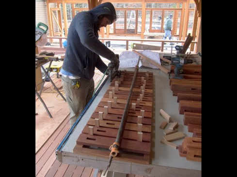 We used small blocks of 1/2-inch MDF as spacers between the slats, clamped the assembly together, and fastened the slats to a cleat frame with stainless-steel brads. With the slats nailed to one frame, we laid the next frame on top and fastened it off.