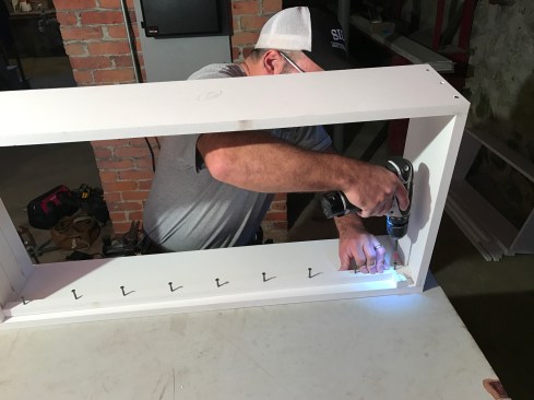 After predrilling the stops and inserting screws in my holes, I screwed the stops into place, using a spacer block as a guide to space them evenly from the inside edge of the frame.