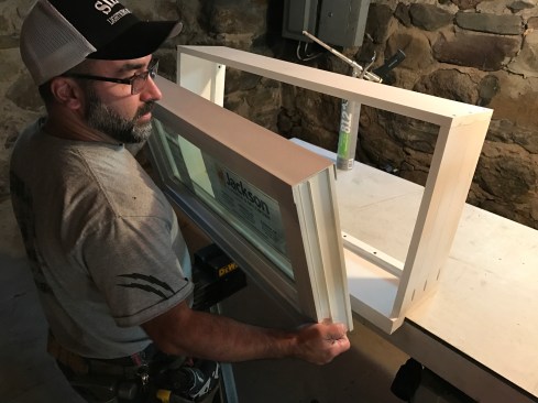 Next I squeezed out a bead of caulk (I used DAP Dynaflex 230, an elastomeric latex sealant) onto the front side of the stops and pressed the window against the stops, leaving equal space along both sides for insulation.