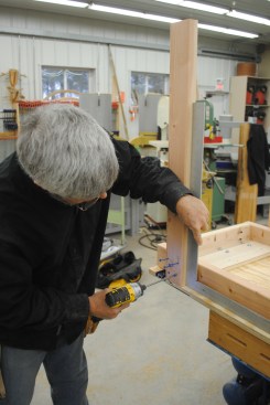 Next screw the 2-by legs to the frame, using a framing square to keep them perpendicular.