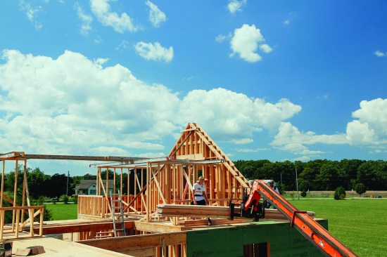 Before the ridge was brought over, the crew stacked the rafters for the back of the house, keeping them low and out of the way.