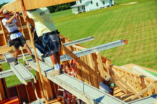 There were no common rafters at the center of this house, so the crew supported the center with a temporary post and braced it back to take the bow out of the ridge.