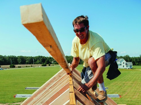 The author removes the temporary strips on top of the ridge, leaving a space for ridge ventilation.