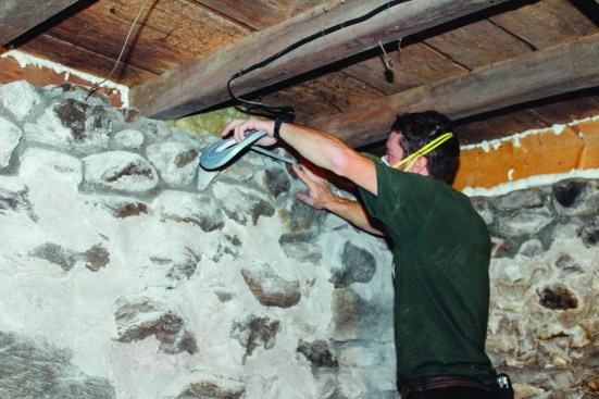 Siga Primur Roll tape bonded the new air-barrier membrane  to the repaired fieldstone wall. First, the tape was pressed  firmly to the stone.
