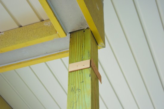 On site, the author began assembling the columns by adding shims to create a plumb surface on each post.