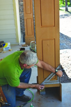 After marking a level reference line across the bottom of the column, the author scribed the base pieces to the sloped concrete porch floor.