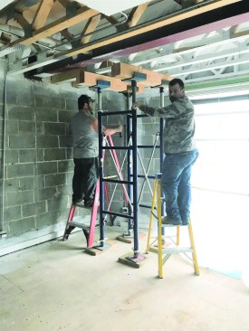 The crew used screw jacks and beams to lift the trusses to their original height.