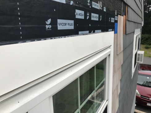 The author builds a four-sided PVC trim "kit" on the ground leaving a gap on all sides between the trim and the window. An additional width of flashing tape extends from the top of the window up under the existing WRB. 