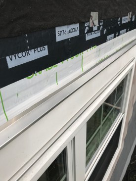 The author uses another length of aluminum drip cap over the trim, which he tapes back to the wall.