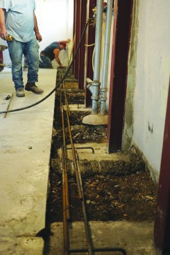 They added #5 rebar along the excavated trench and attached it to pieces of rebar that they had bent over and embedded in the concrete anchors.