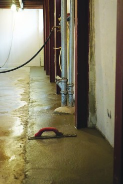 To complete the project, the crew poured concrete in the trench flush with the rest of the basement floor. Anchored at the base and tied into the floor framing above, the vertical beams will stabilize the foundation and resist any further inward movement.