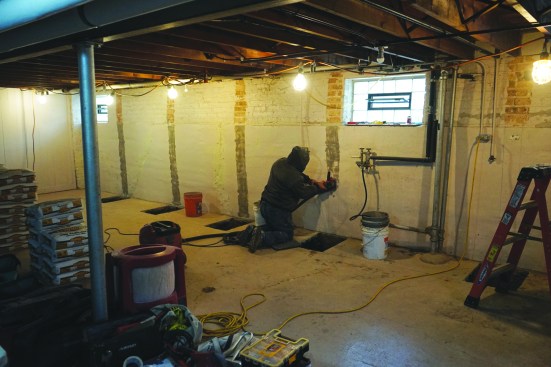 They then ground the paint off the foundation wall at each beam location.