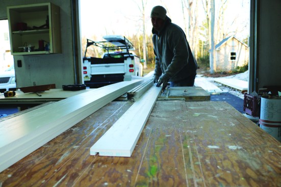 To join the fascia to the soffit, this crew member runs the 1-by fascia material through a table saw to create a dado groove.