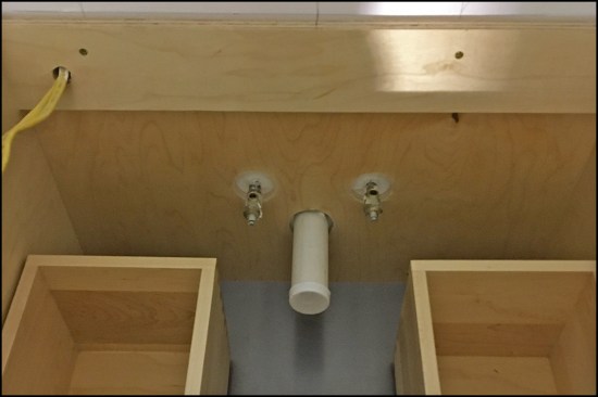 The example vanity cabinet installed. A 1/2-inch hole was made to run power to an outlet on the side of the vanity (upper left corner of photo).