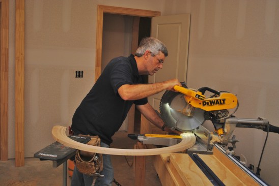 To make the cuts on a miter saw, support the free end of the circular trim in back of you.