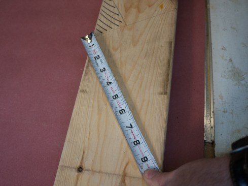 Tail cut. In our example, the roof has a 9-inch overhang as measured on a level plane from the building (see Roof Plan, page 1). I lay this out by measuring horizontally across the rafter from the birdsmouth shoulder. I mark a plumb line here using the layout square, the same way I did for the top cut and for the shoulder of the birdsmouth.
