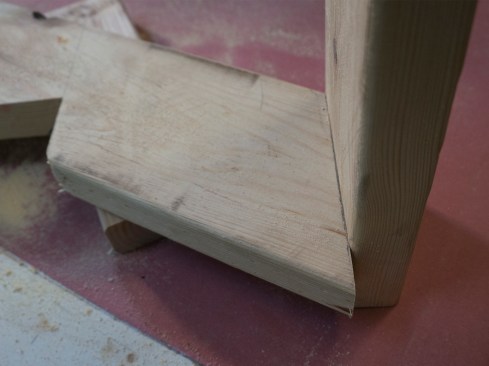 Soffit cut. The plumb cut at the end of the rafter is longer than the 2x6 subfascia is wide. Therefore, I want to cut off the long point of this plumb cut so it doesn’t protrude below the subfascia or interfere with the soffit material. Hold a scrap of the subfascia material in position and mark the bottom edge.