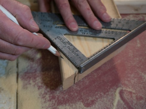 To make the soffit cut, I hold my square on the plumb cut, and mark a “level” line square to the plumb cut.
