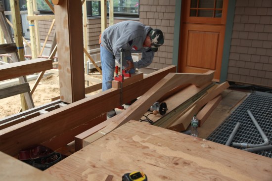 To make the arbor beams, the crew laminates multiple layers of 4-inch-thick cedar together. Two pieces of 4-by-6-inch cedar glue to the bottom side of a 4x10, while a short 4x4 clamps to the top. Dominoes align the pieces during the glue-up.
