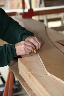 A crew member traces a line 1/4 inch outside the template with a spacer block and then cuts along the line with a 10 1/4-inch circular saw.