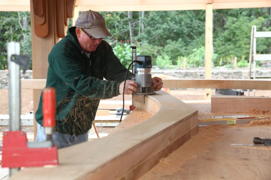 A router with a top-bearing flush-trim bit follows the template for the first finish cut.