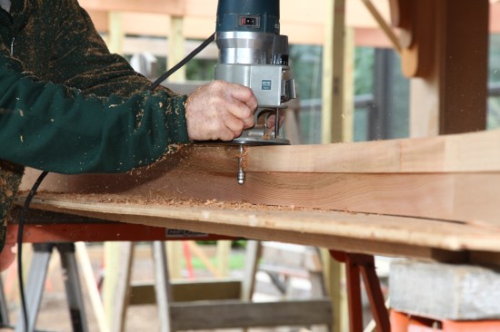 The beam is flipped over and an up-cut spiral bit rides on the first surface to finish the cut.