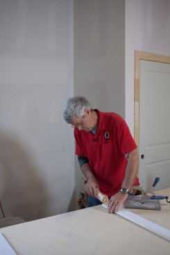 After cutting all the pieces and drilling them for pocket screws, the author applies glue to the ends of the frame before screwing the frame together.