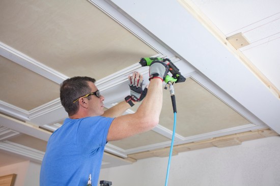 A crew member installs the same panel molding that was used on the panels to complete the transition down to the intermediate layer.