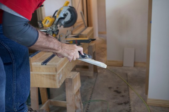 A hand plane removes material from the top of the bed molding, which created an even reveal along the bottom edge of the molding. 