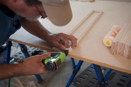 The ceiling design called for surface applied panel molding on the minor beams. A crew member assembles the rectangular trim detail on the work bench.